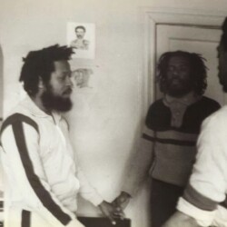 A black and white photo of three men in a room.